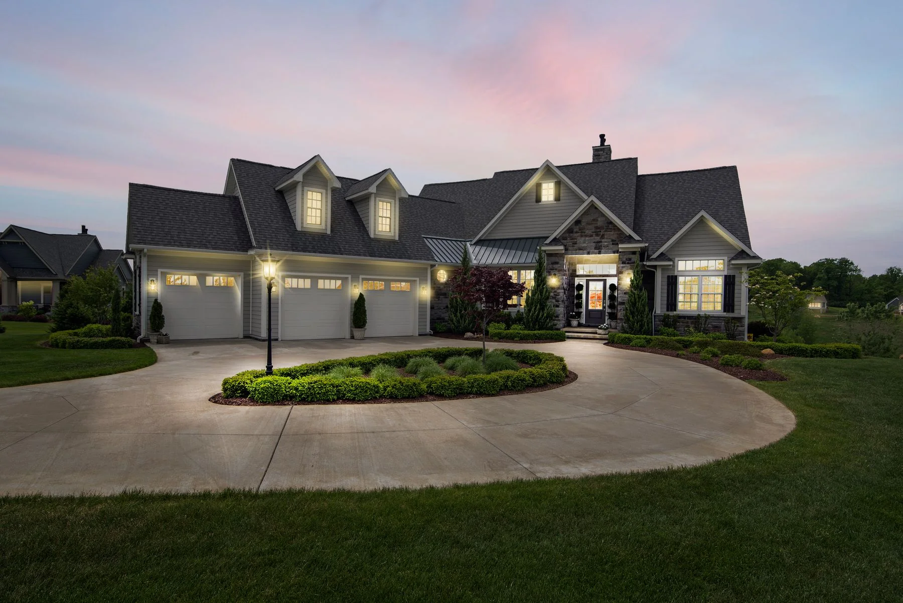 Illustrative stock photograph of a landscaped suburban property illuminated at dusk