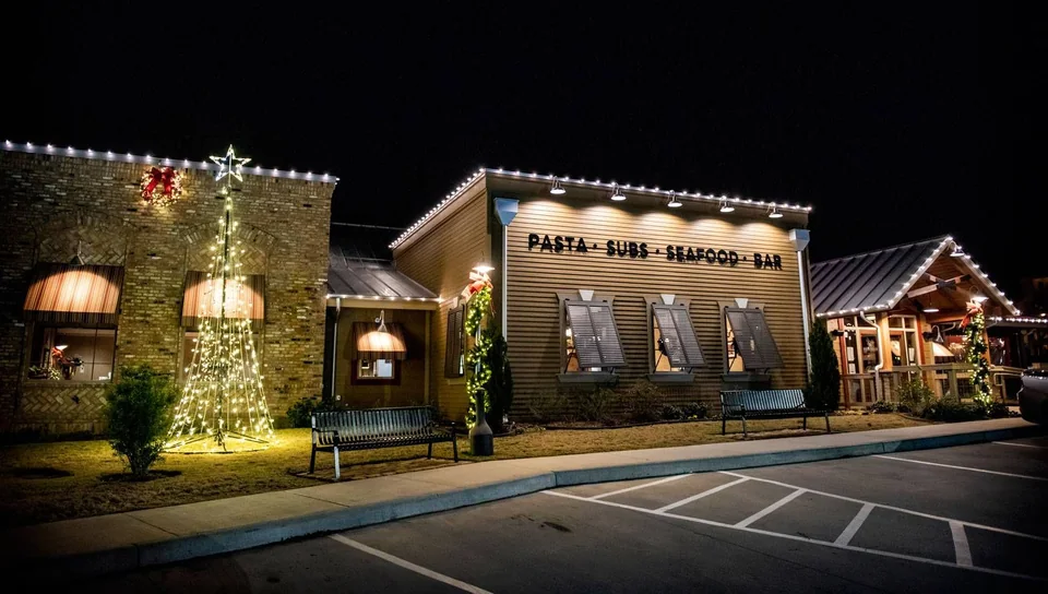 Storefront roofline lights, wreaths and an illuminated cone tree