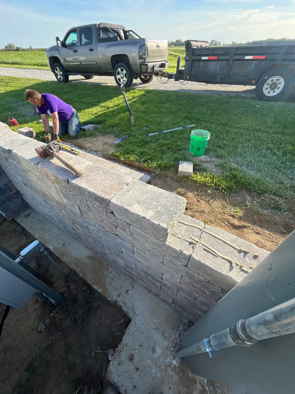 Worker setting concrete blocks along a wall under construction